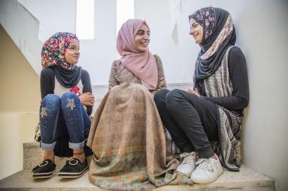 Three Jordanian young women in a hallway talking.