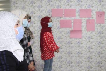 A group of young people stand next to their artwork. 