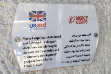 A wall sign in al karak hospital describing mercy corps' work to rehabilitate accommodations.
