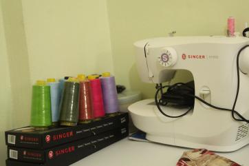 A sewing machine and spools of thread.
