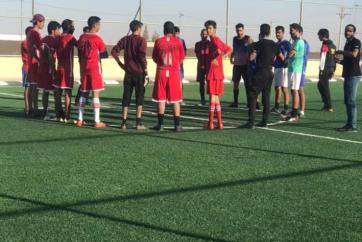 Players gathered on the newly repaired soccer pitch.