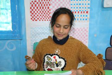 A young person working on craft projects.