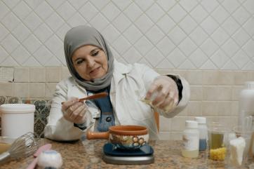 A jordanian biologist mixes ingredients for natural cosmetics products.
