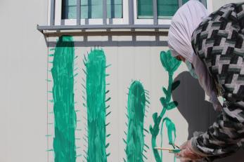 A young person paints a mural.