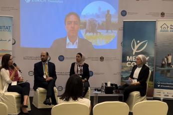 A panel sitting in chairs at a conference.