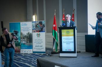 The country director of mercy corps jordan giving a speech at the world civil defense day celebration.