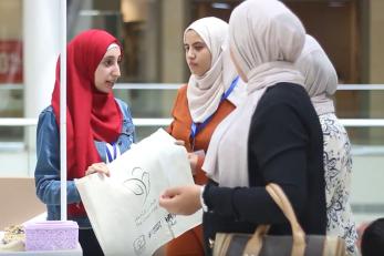 Girls handing out reusable bags at the mall