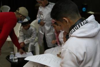 A young person reading the script to a play.