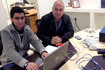 Two adults using a laptop computer.