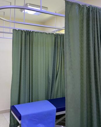 A medical bed and curtain partition.