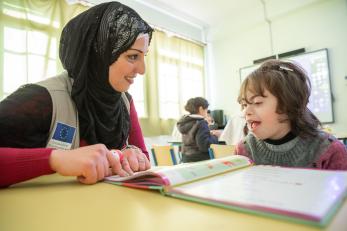Mercy Corps employee works with student with disabilities.