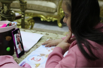 A Jordanian girl interacts with her teacher on a phone video chat.