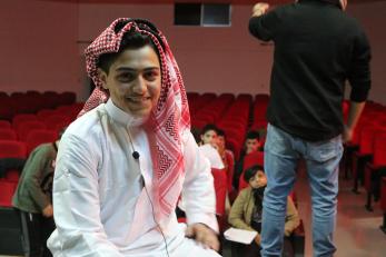A young person in a theater wearing their costume for a play.