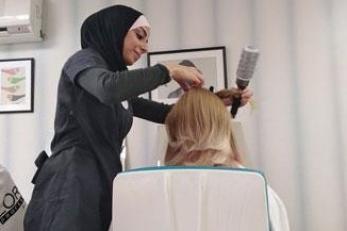 A person cutting the hair of a customer.