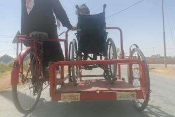 A bicycle with side trolly to transport a wheel chair bound person. 