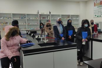 A group of young people standing at lab tables.