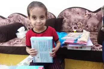 A young person holding educational materials.