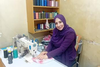 Jordanian entrepreneur in her workshop hand-sewing traditional keffiyehs.