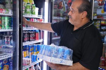 Ayad restocks the fridge at his mini-mart after receiving the goods he ordered online through Yaseer’s app.