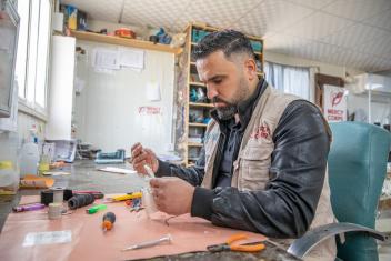 Tamer, a volunteer at Mercy Corps’ disability equipment repair workshop, assembles the pieces of Mohammad’s new 3D printed prosthetic hand.