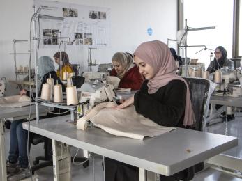 Jordanian women work in sewing company environment.