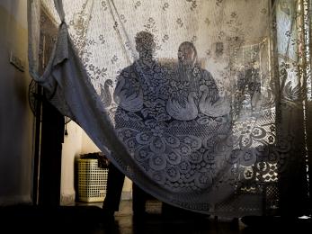Two people veiled by fabric.