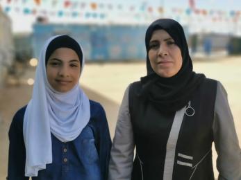A mother and daughter posing for the camera.