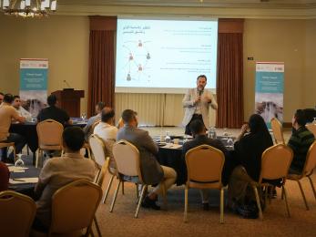 Jordanians meeting in a conference room with a speaker as center of attention.