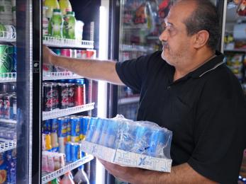 Ayad restocks the fridge at his mini-mart after receiving the goods he ordered online through Yaseer’s app.