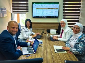 A group of people sitting at a table having a meeting.