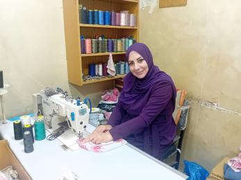 Jordanian entrepreneur in her workshop hand-sewing traditional keffiyehs.
